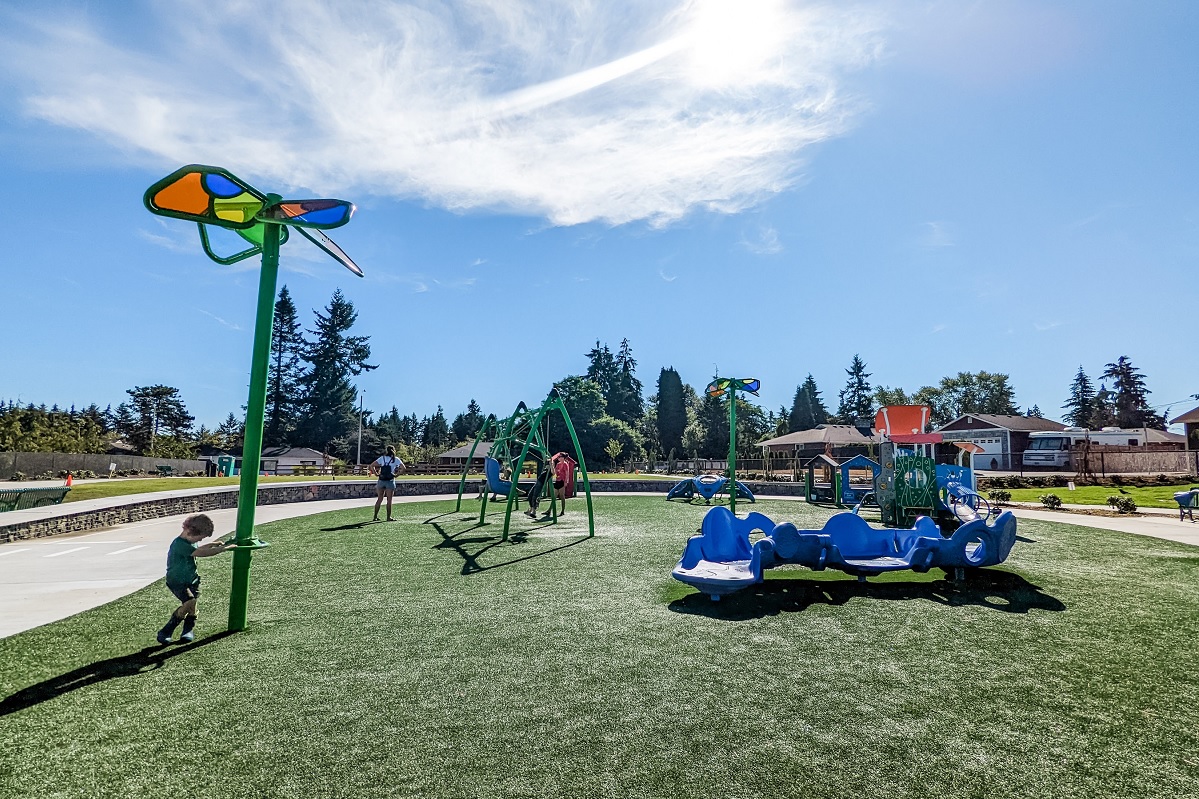 Boy and other kids play on the new playground equipment at Emma Yule park