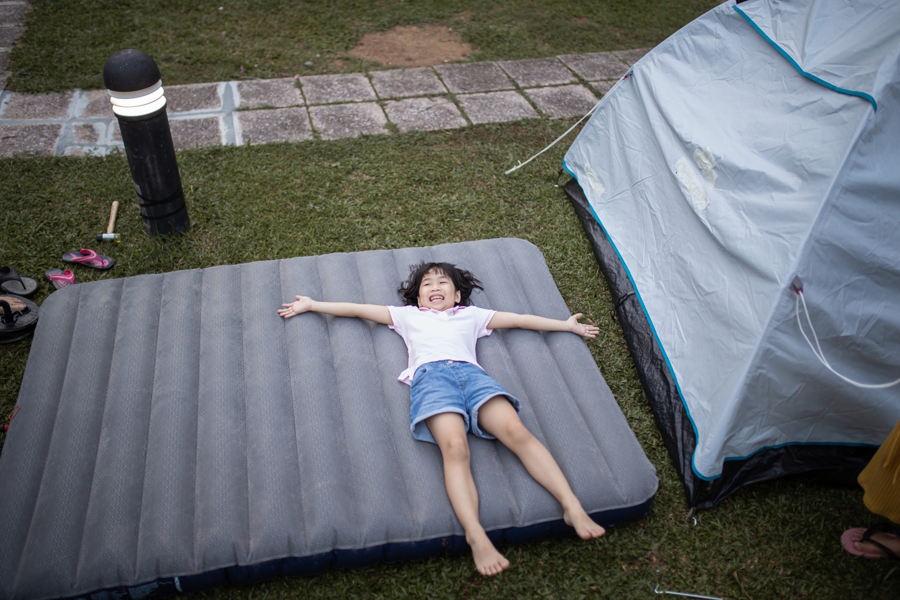 girl lying on a large air mattress outside
