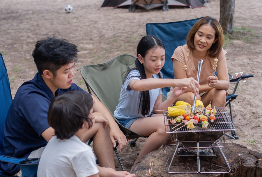 Asian family cooking over a camp stove