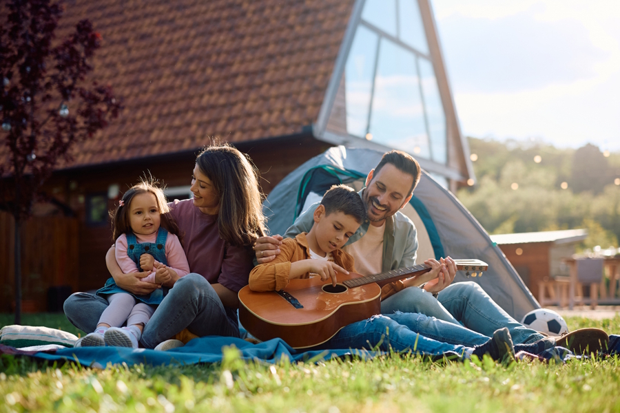 family singing while camping in backyard