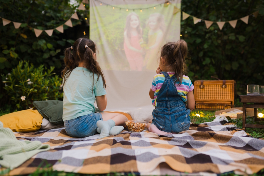 girls watching a movie in their backyard