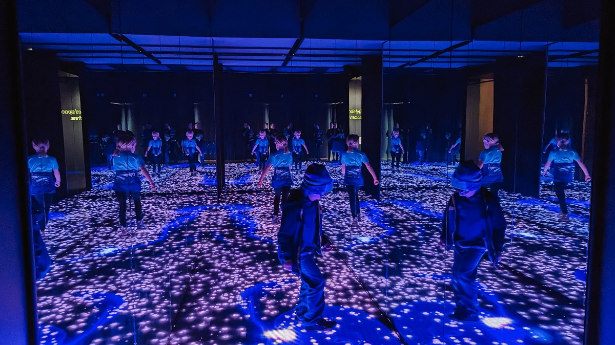 Kids play in the first exhibit room of interactive light art at WNDR Seattle