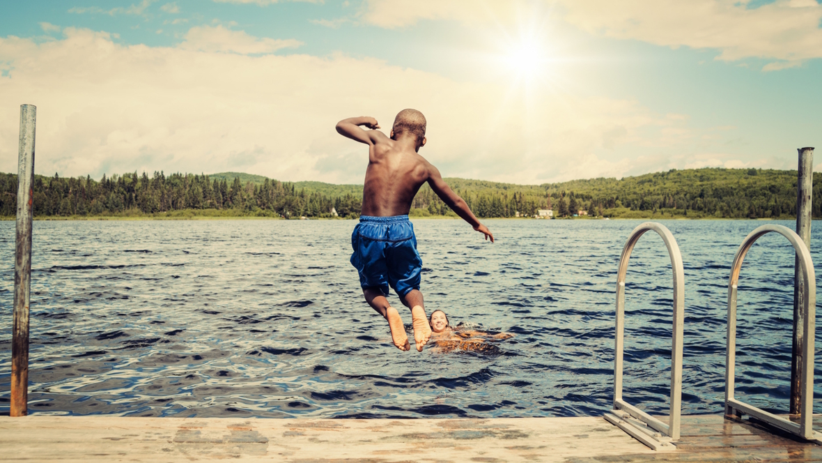 boy jumping into a lake