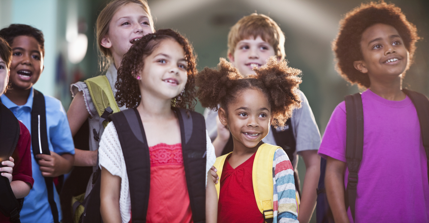 Group of children of different ages wearing backpacks