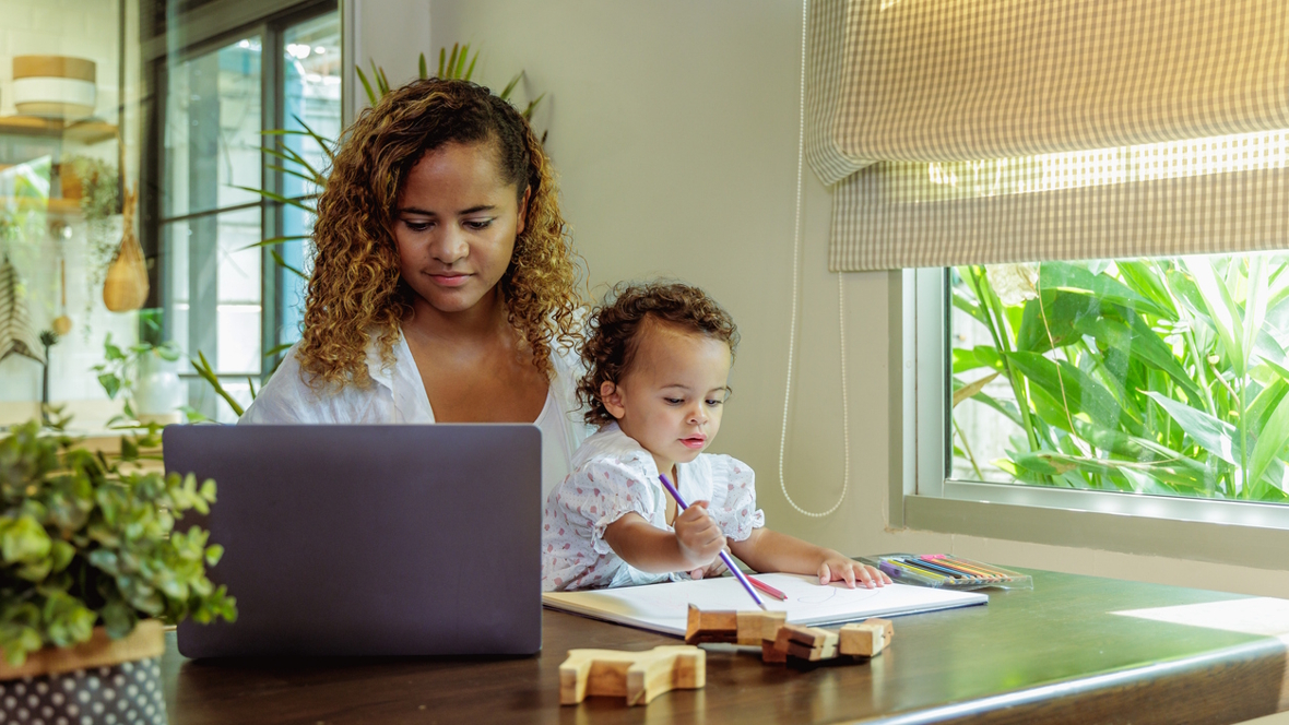 mom working at home with child on her lap