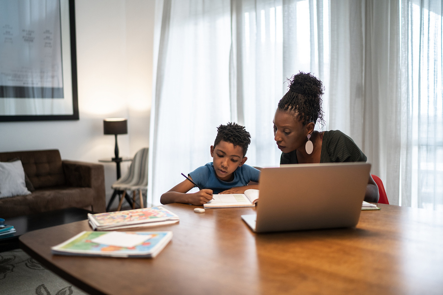 mom supports son in writing down what he needs to remember