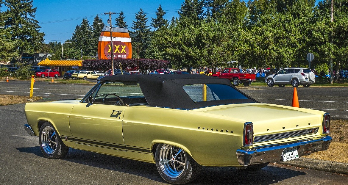 A pale yellow Ford Fairlane GT is parked for a car show at Triple XXX Rootbeer Drive-in Issaquah among family activities in Seattle for car-loving kids and families