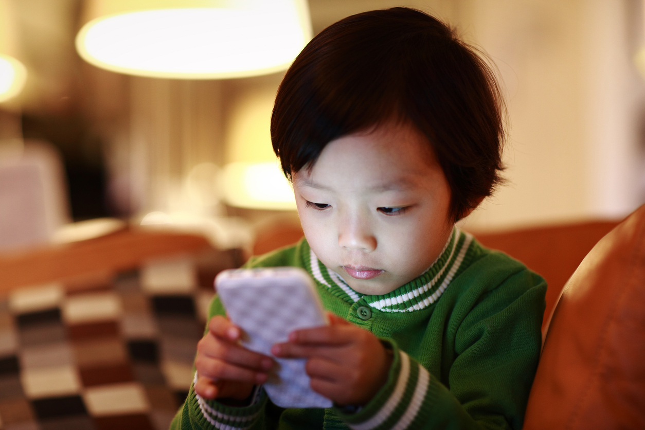 young child is captivated by a cell phone screen