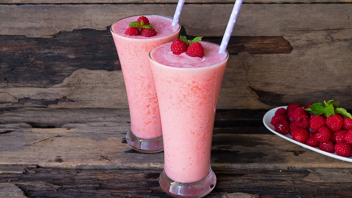 Raspberry drinks with straws and fresh raspberries on top