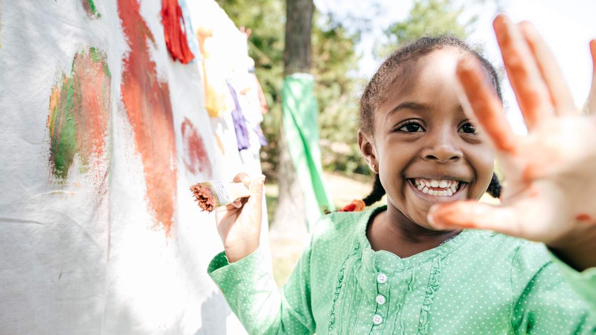 girl painting a messy outdoor art project