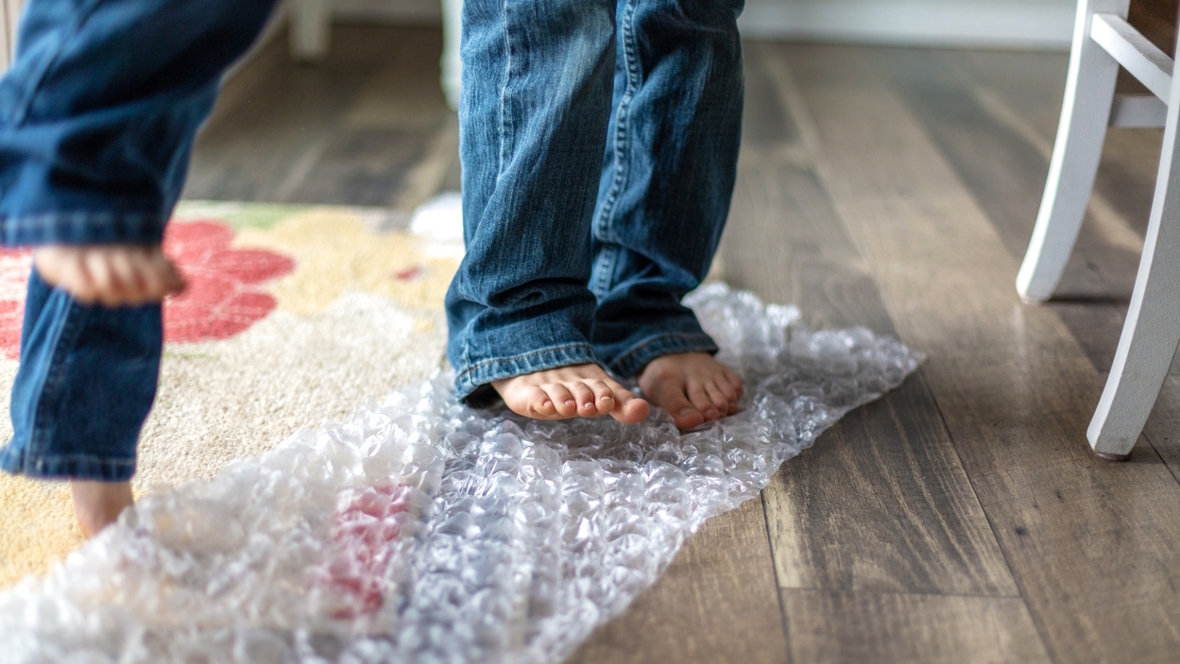 Feet of a child standing on bubble wrap outdoor messy art project