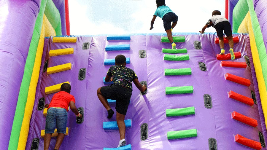 Young kids climbing an inflatable obstacle course at Bounce the City, coming to Seattle in July