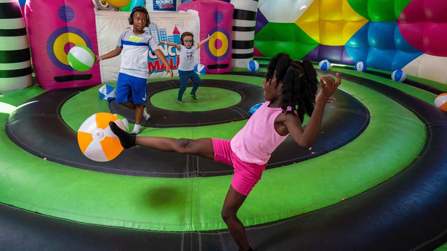 Young kids wearing headphones for a silent disco in an inflatable bouncy house at Bounce The City, coming to Seattle in July