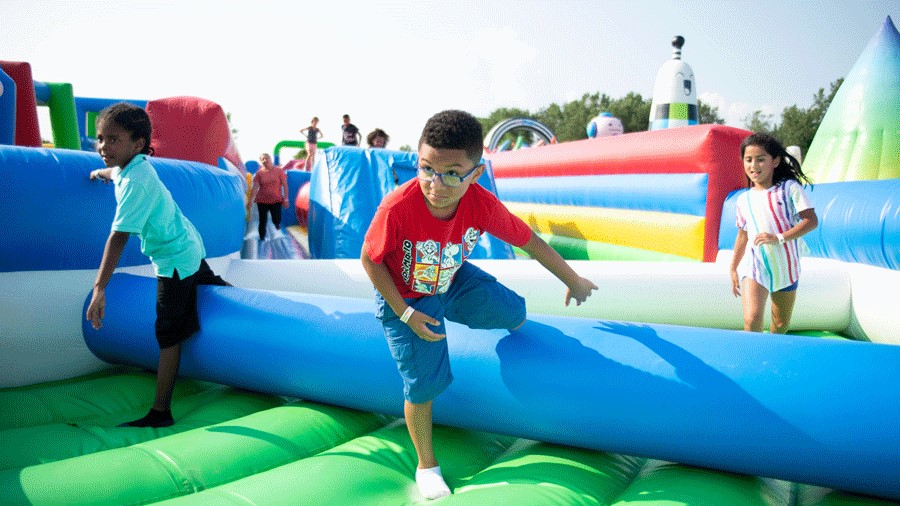 Young boys climbing the obstacle course at Bounce the City, in Seattle for July
