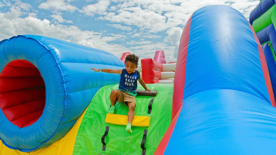 Young boy sliding down the inflatable obstacle course at Bounce The City