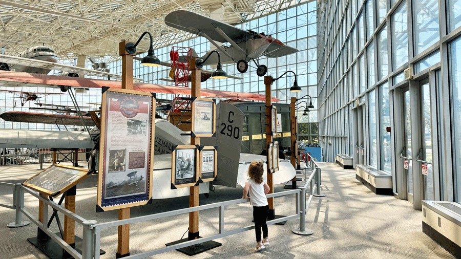 Toddler looking at historical details of airplanes at The Museum of Flight’s gallery.