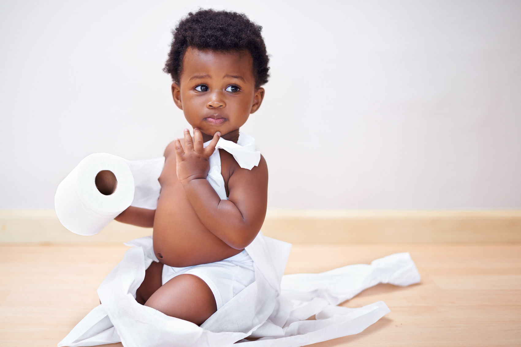 baby looking concerned while wrapped in toilet paper during the cost of living crises