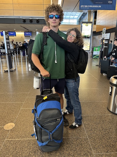 Lighthouse Mom Moffett Burgess hugs her very tall son at Seatac airport
