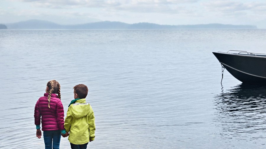two kids staring at the water in Alaska on a cruise ship excursion