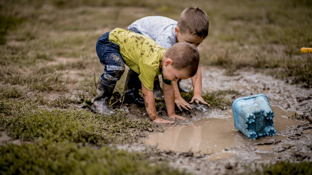 Two boys playing in the mud KidsQuest museum Bellevue