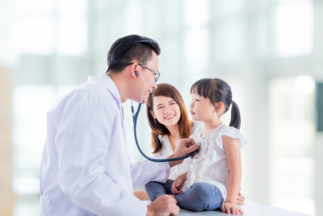 Doctor checking a young girl's heart beat at a doctor visit