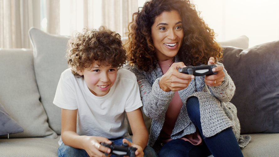 mom and son playing video games together on a couch