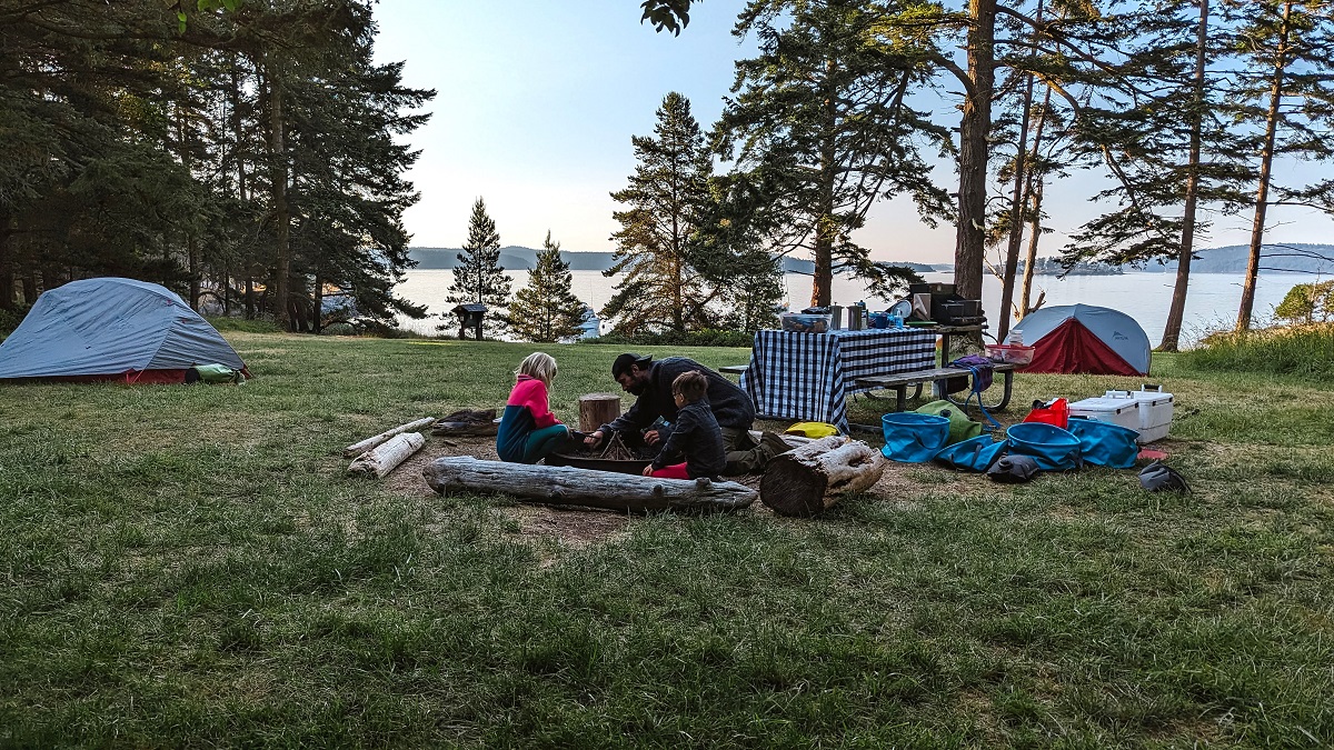 A San Juan Outfitters guide leading a family kayaking tour teaches young guests how to build a fire