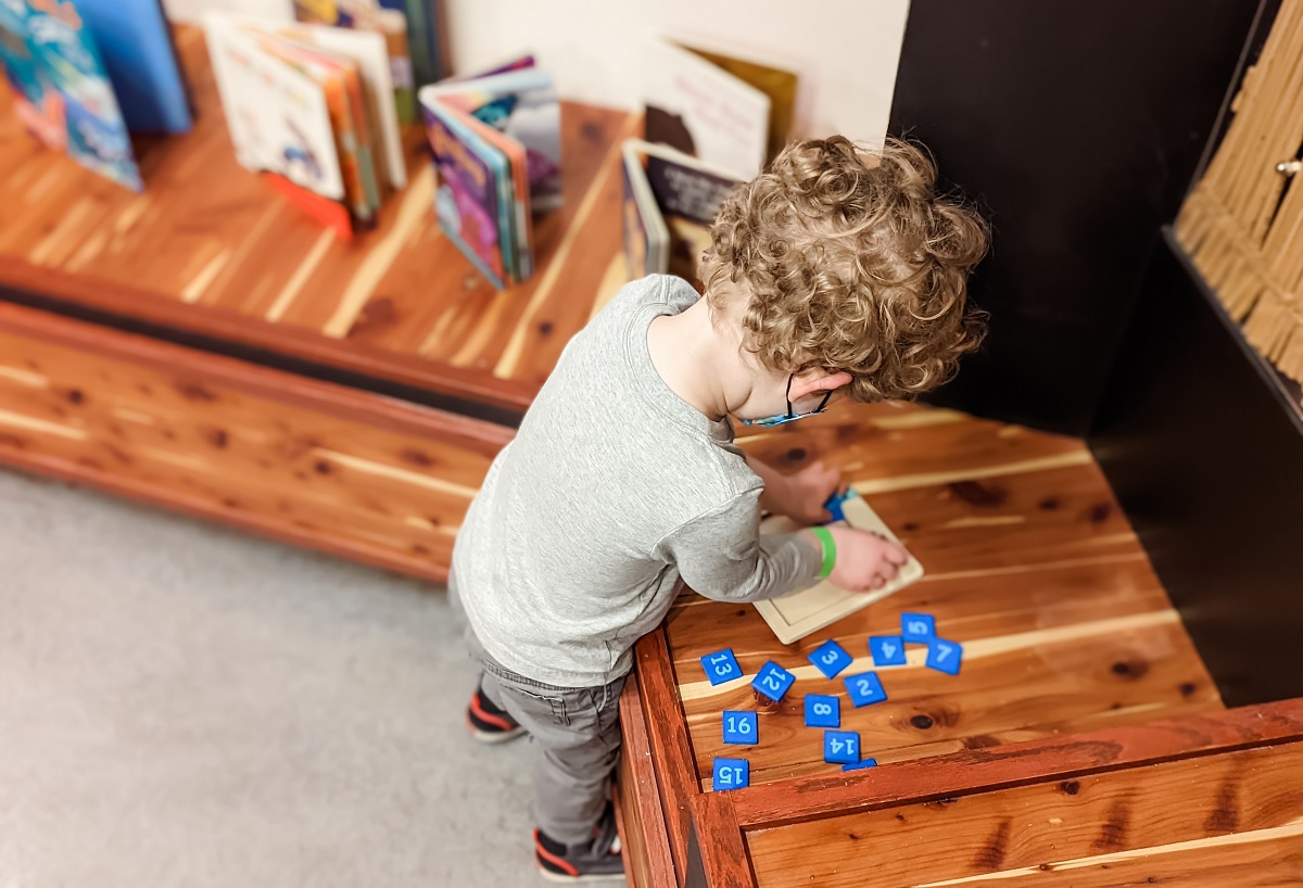 Young child plays with books and puzzles at the Seattle Children's Museum