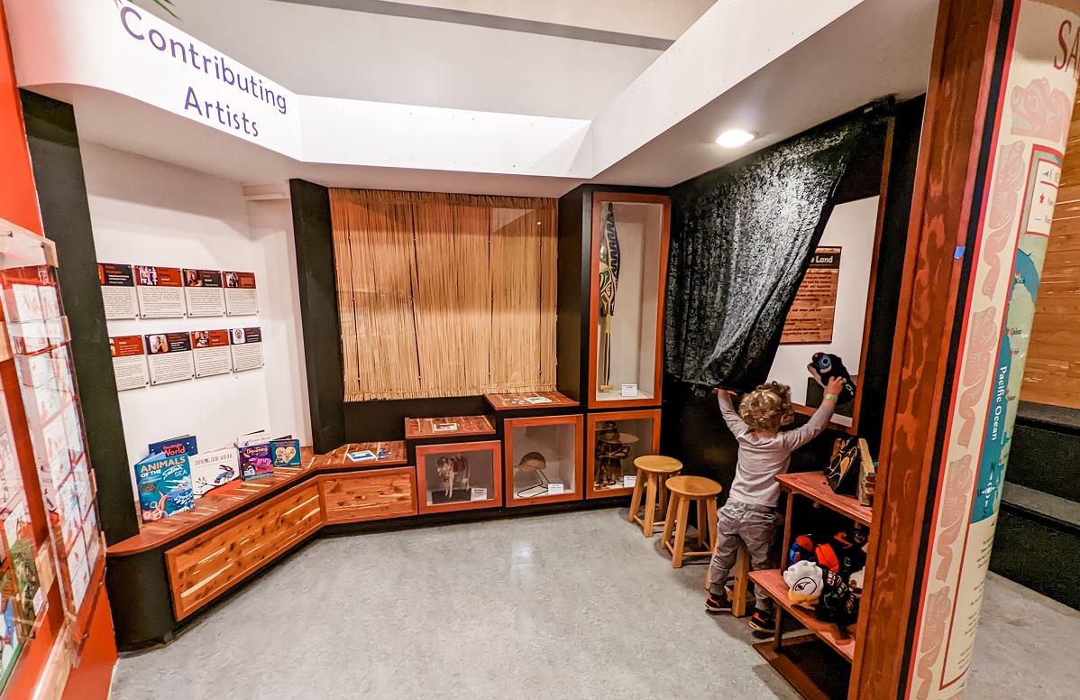 Young boy looks at items in the Tribal Tales exhibit of the recently reopened Seattle Children's Museum at Seattle Center