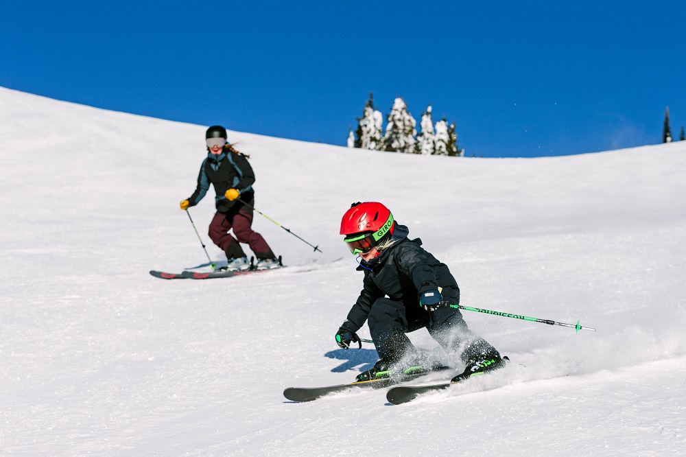 Child and parent skiing at SilverStar Mountain Resort, B.C., Canada