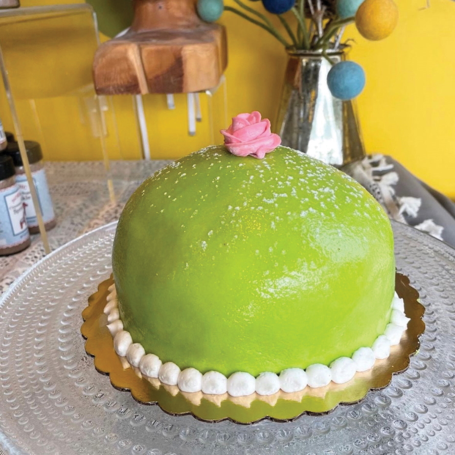 Green princess cake with a pink rose on top