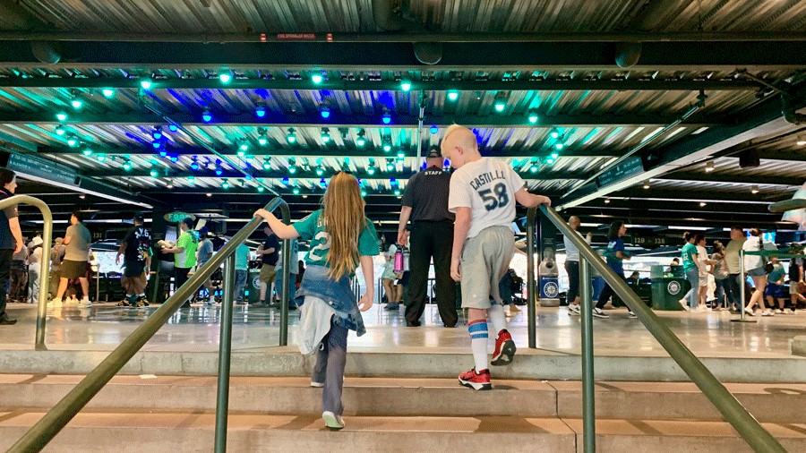 Two kids walk up the stairs at T-Mobile Park for a Seattle Mariners game
