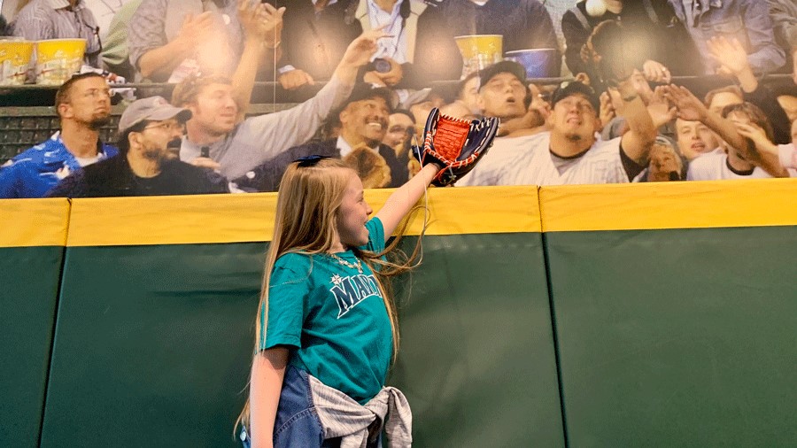 Young girl pretending to catch a ball at T-Mobile Park