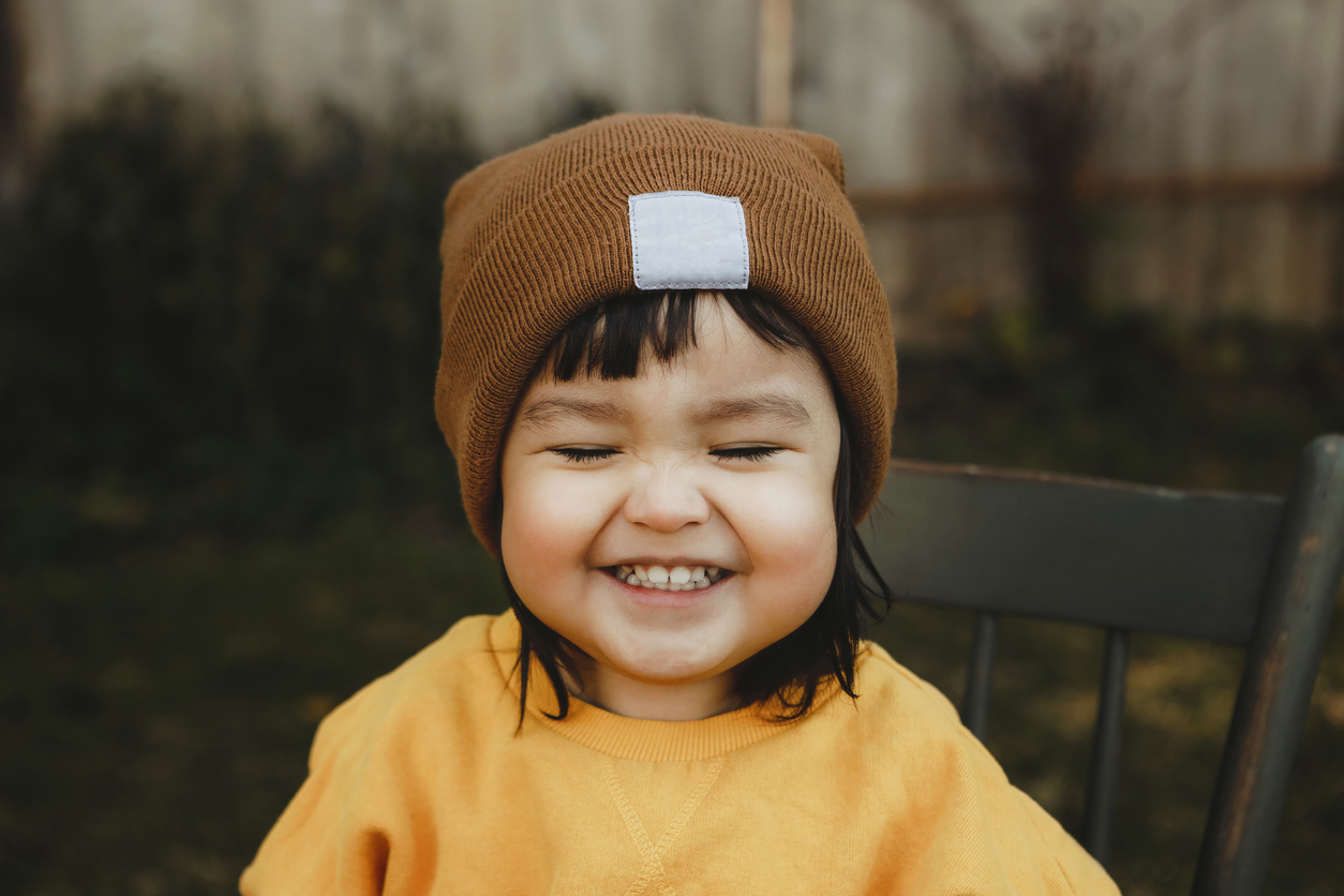 smiling toddler in fall hat and sweater