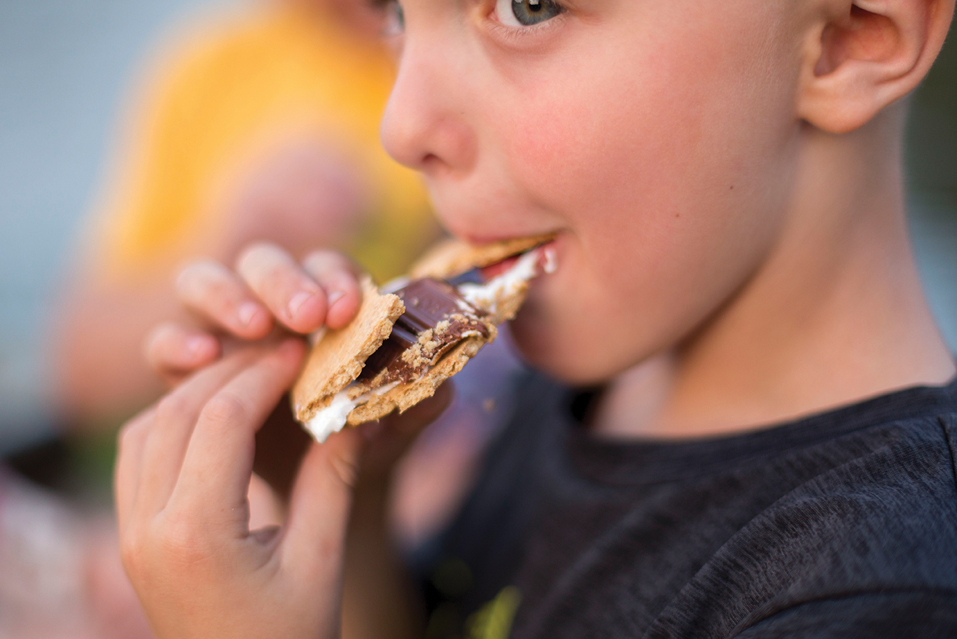 boy biting into a smore