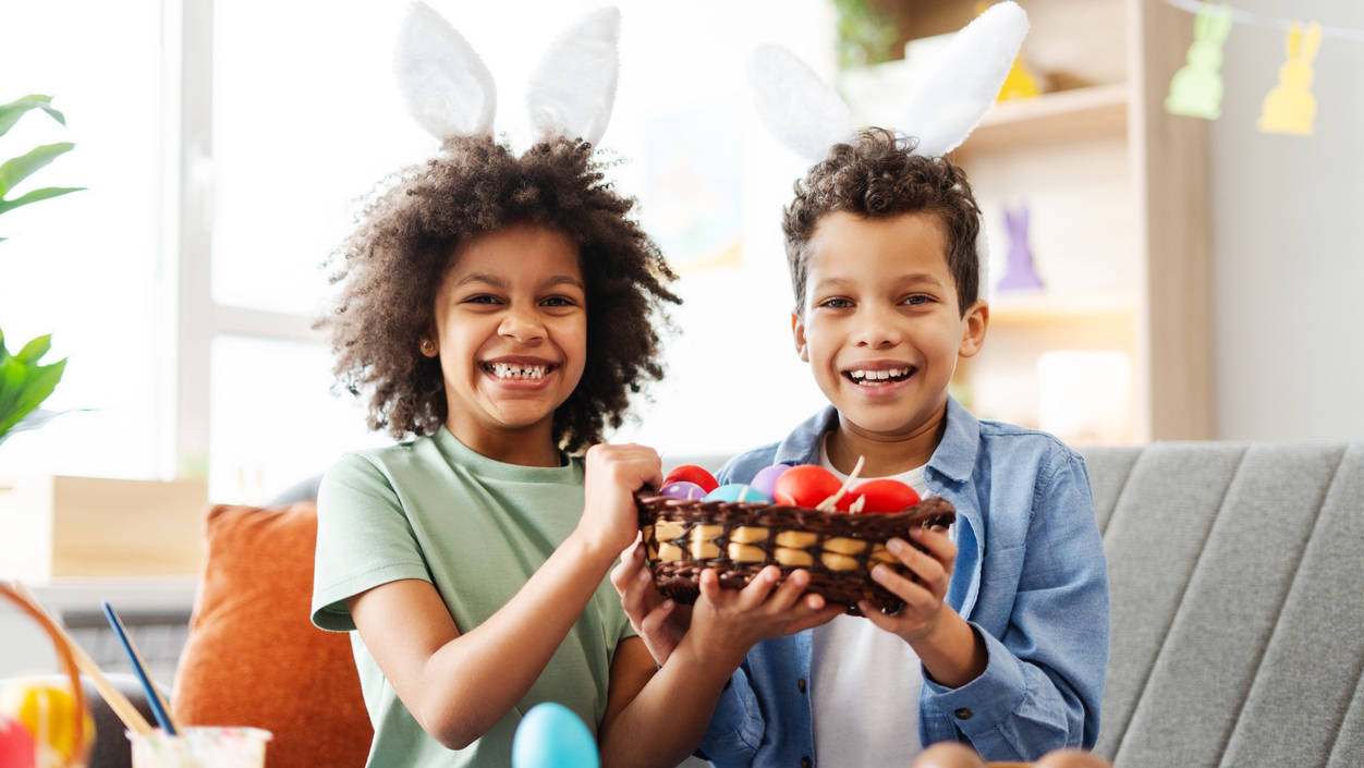 two kids wearing bunny ears holding a basket of dyed eggs and egg alternatives