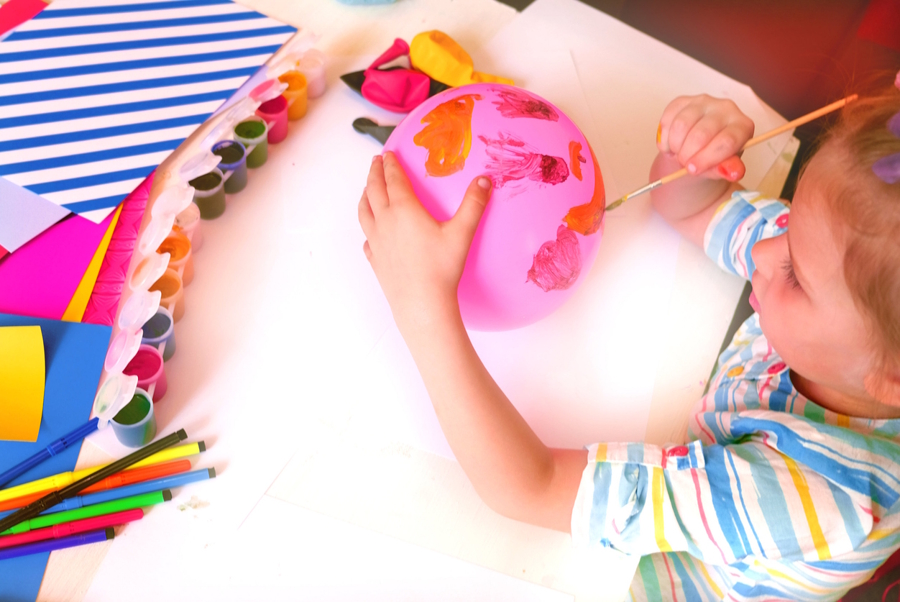 child painting a balloon