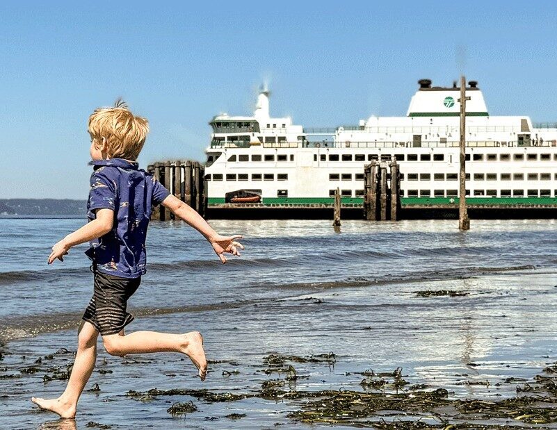 young boy running on the beach near Edmonds ferry terminal, one of the many things to do in town