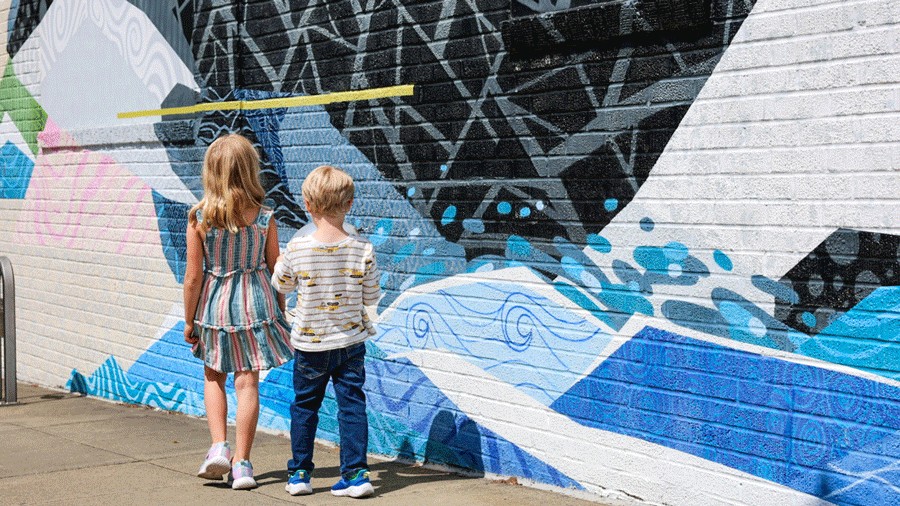 young kids walking in front of a mural in downtown Edmonds, a charming city with lots for kids to do