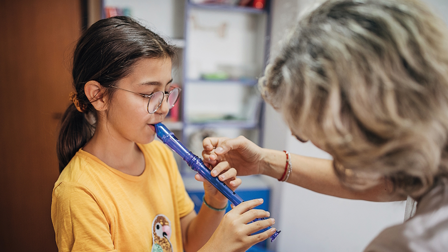 young girl learning how to play the recorder