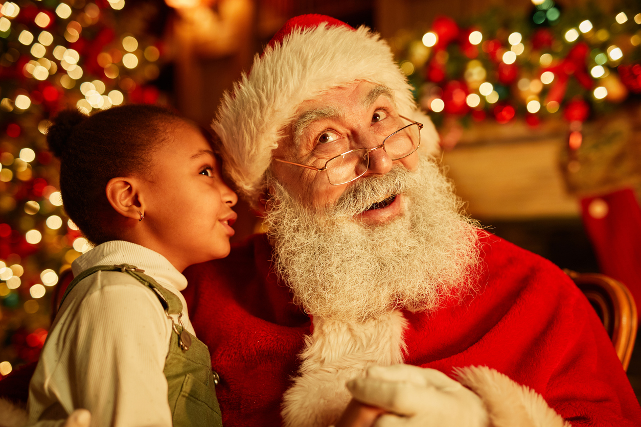 Santa photos Seattle best place to get Santa photos a little girl whispers into Santa's ear during a photo session