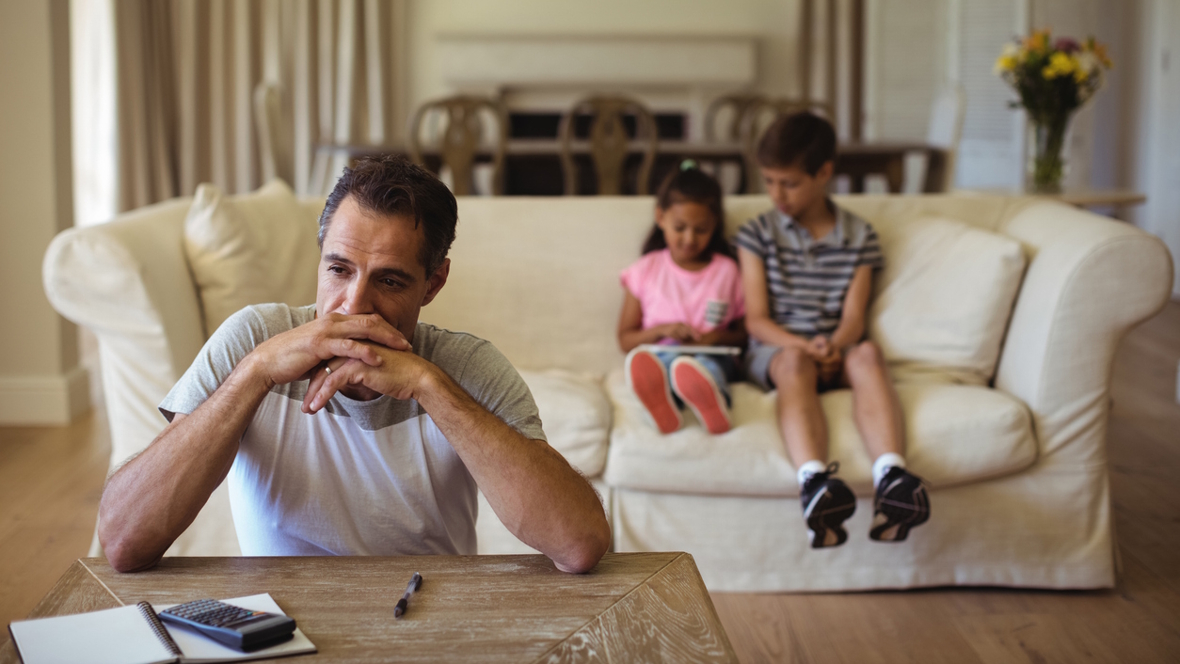 dad sitting with kids looking thoughtful, he has lost his job