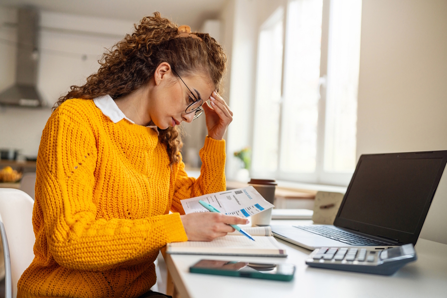 woman trying to balance her budget looking stressed out