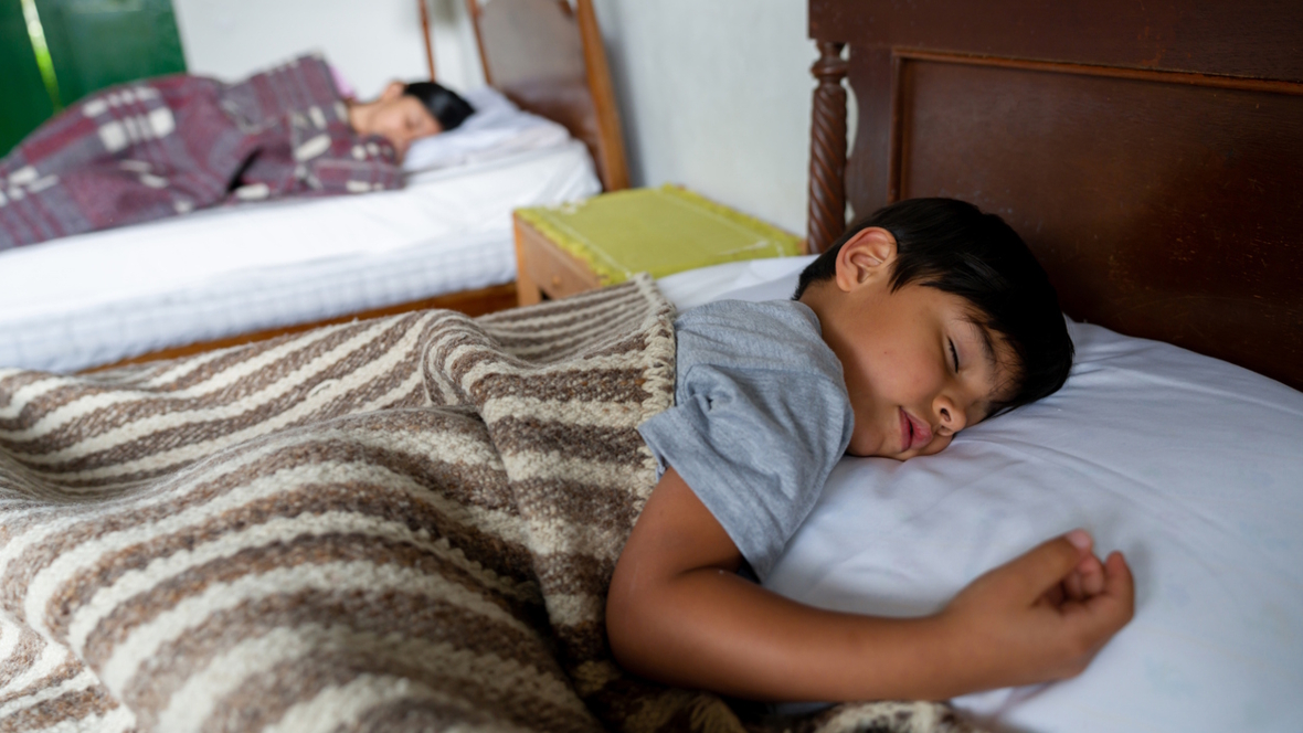 two boys sleeping in beds