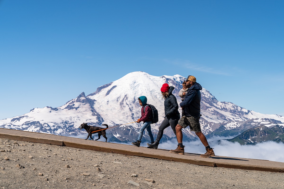 Family hiking at Crystal Mountain in summer with view of Mount Rainier in the background
