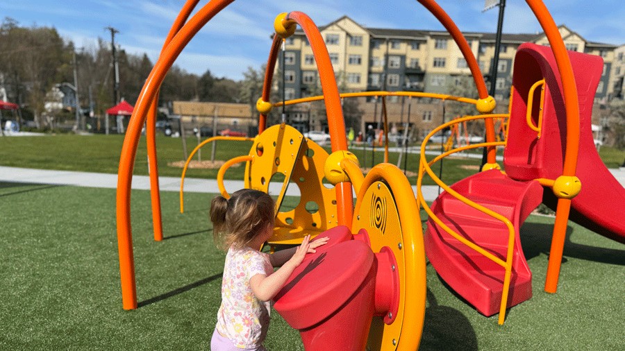 young girl playing drums on a playground at Cheryl Chow Park in Seattle
