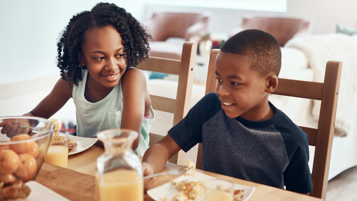 Two siblings eating breakfast together