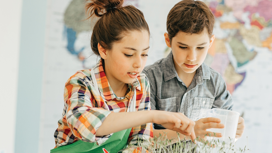 Two kids doing a science experiment involving plants