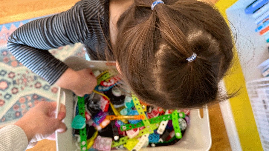 young girl picking a prize from the transition bin after an indoor play date