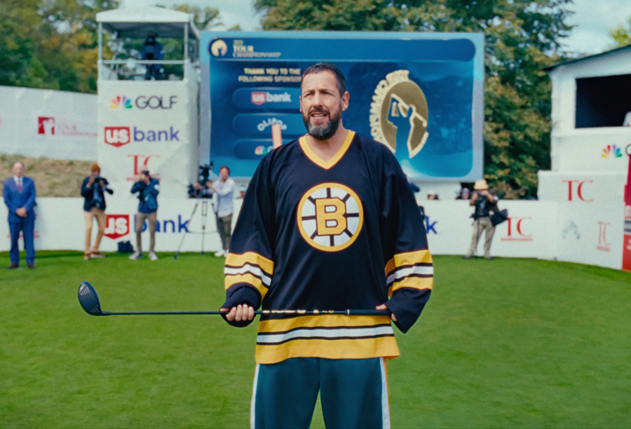 Adam Sandler in a hockey jersey holding a golf club in the movie Happy Gilmore 2